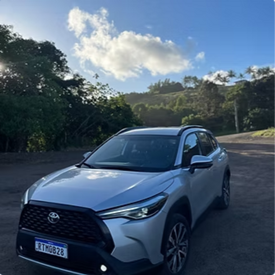 Toyota Corolla Cross prata em estrada cercada de mata