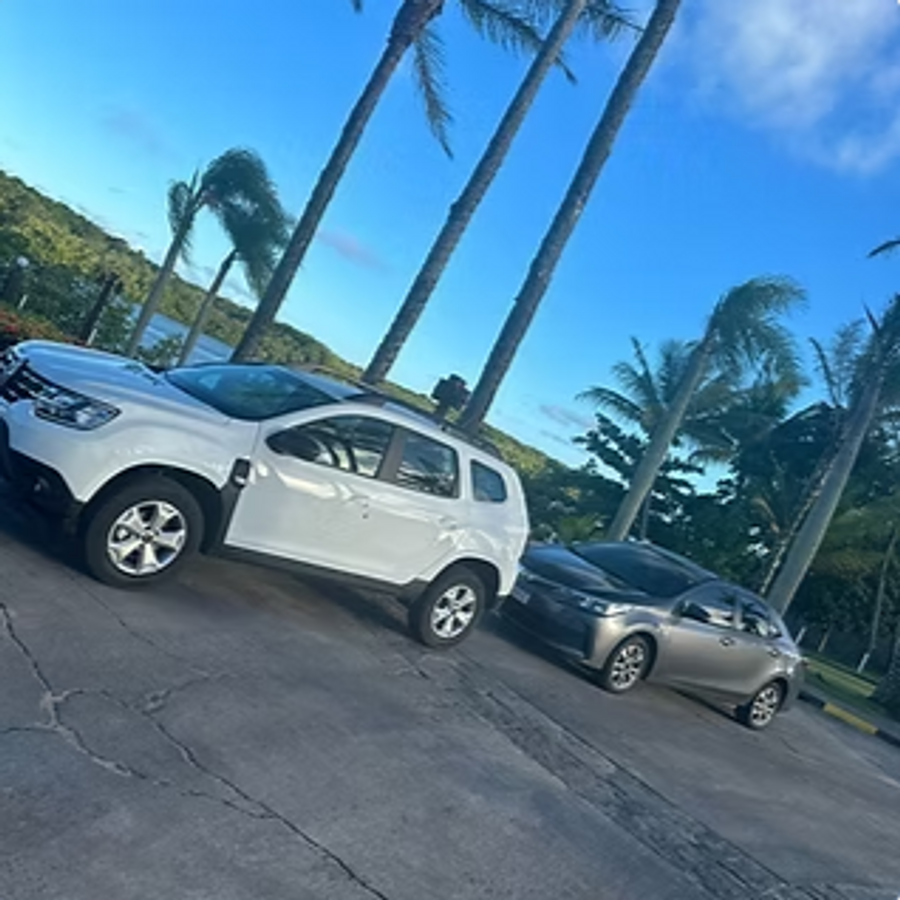 Renault Duster branco estacionado ao lado de um Corolla